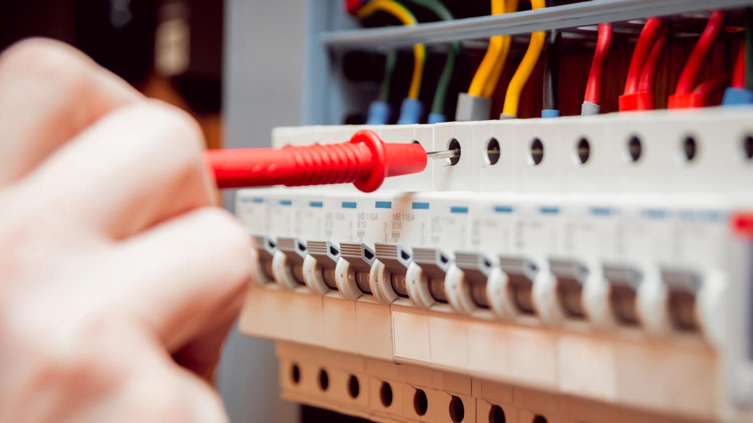 A person inspecting a circuit breaker