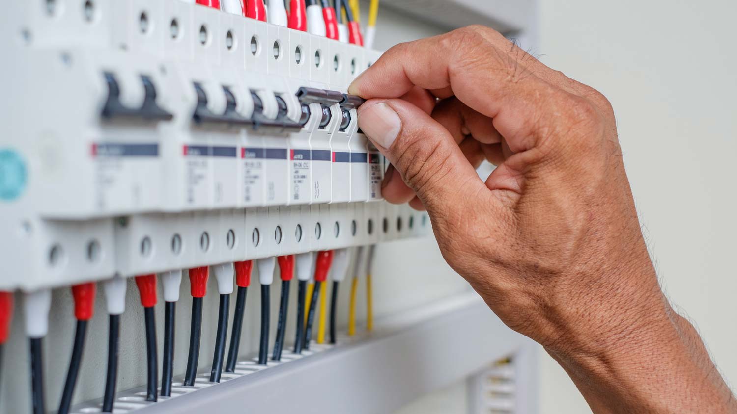 A person opening a circuit breaker