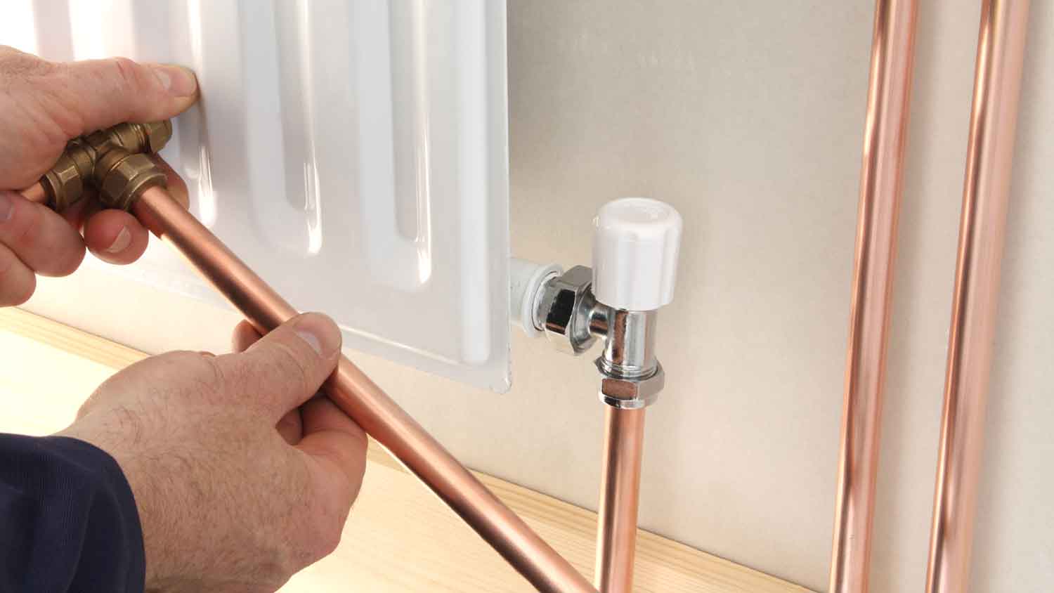 Plumber installing radiator copper pipes