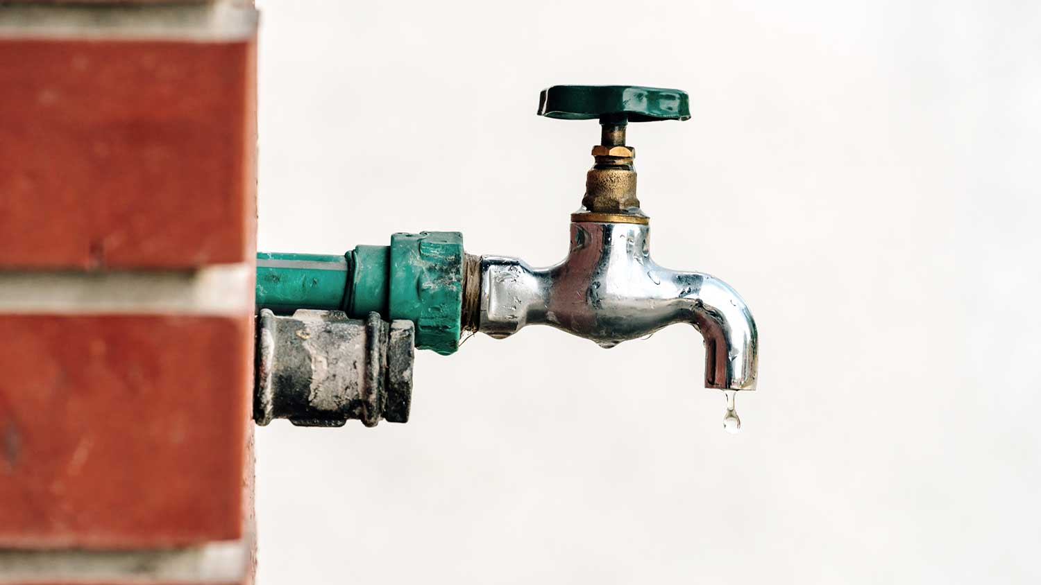 utdoor spigot installed on a brick wall