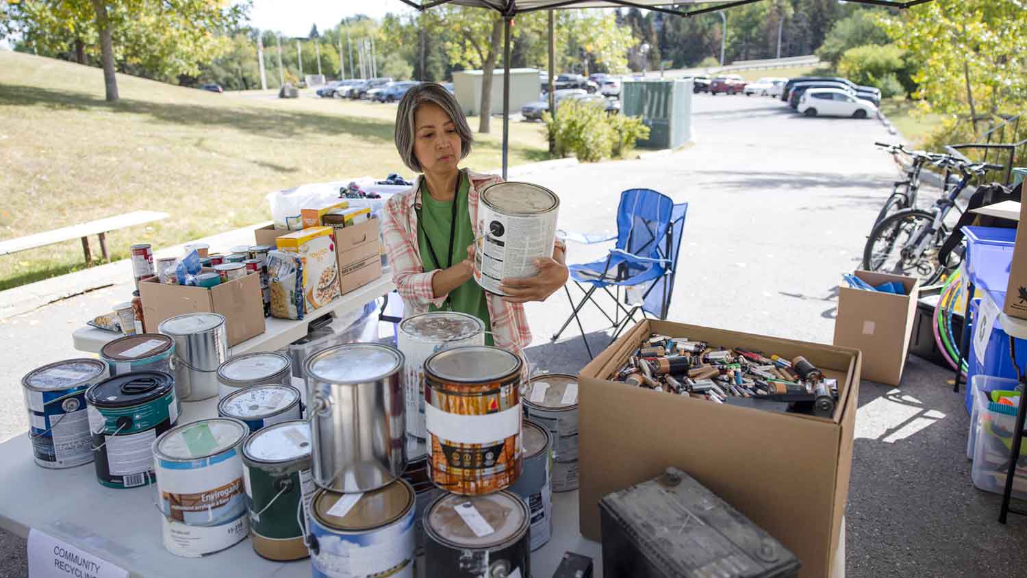 Woman reading paint can label at recycling center