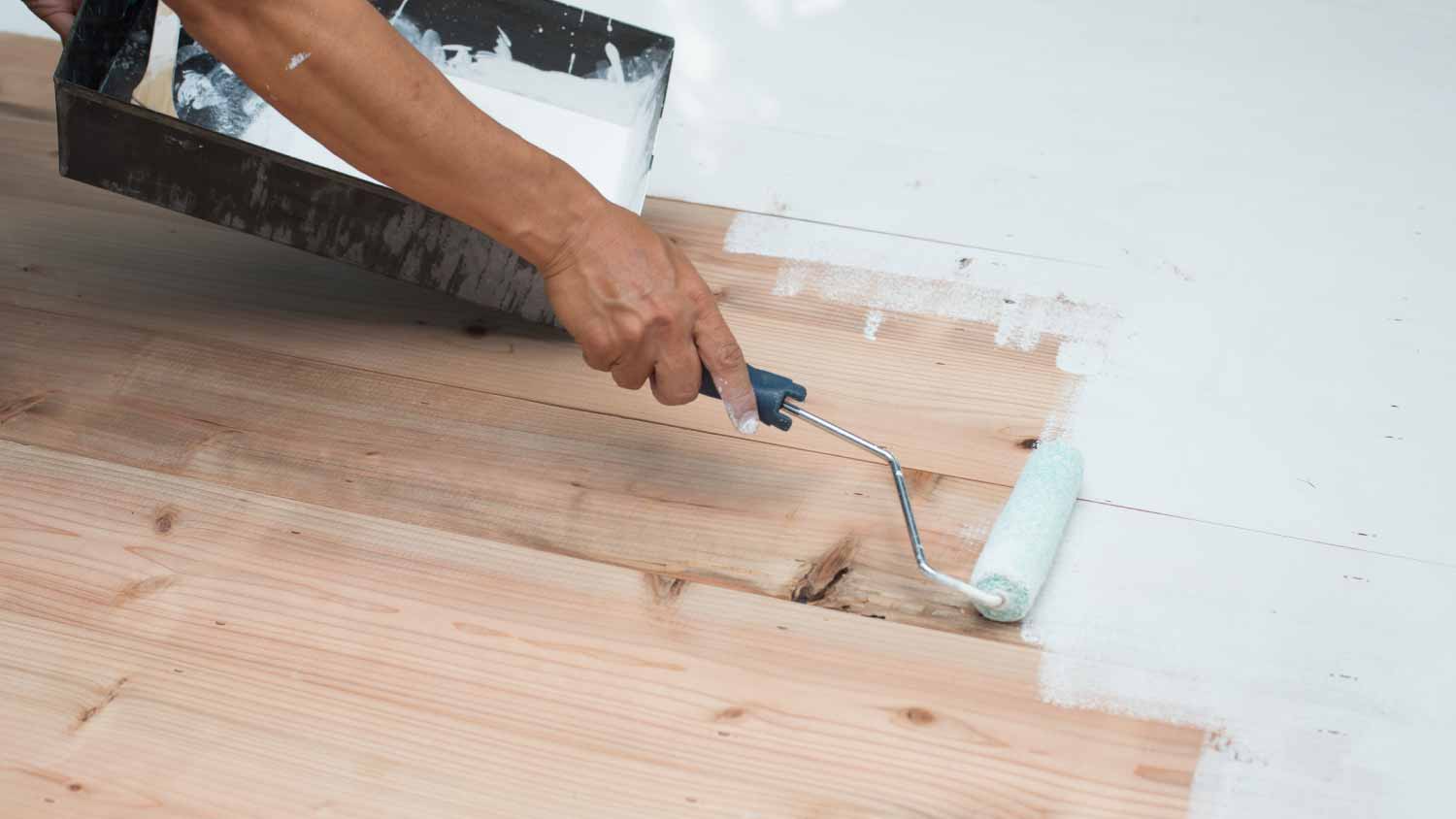 Close up of a man painting hardwood floors