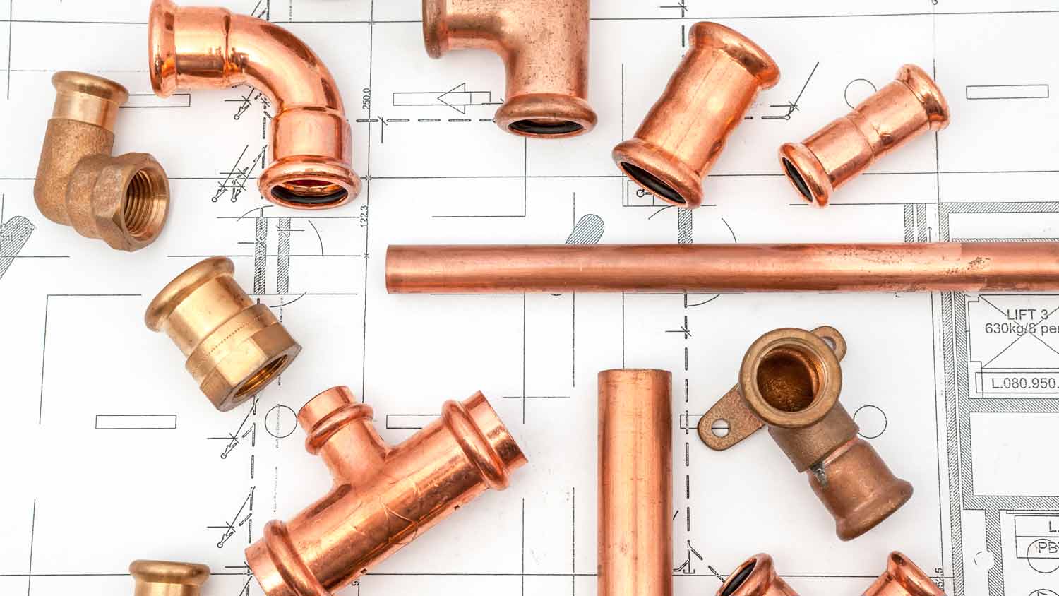 copper plumbing pieces on blueprint