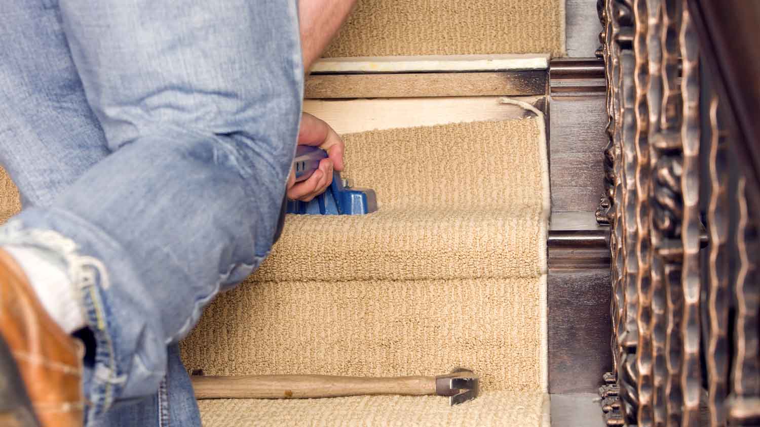 A person installing carpet on stairs