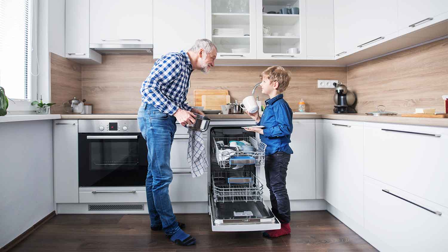 Grandpa and grandson unloading the dishwasher