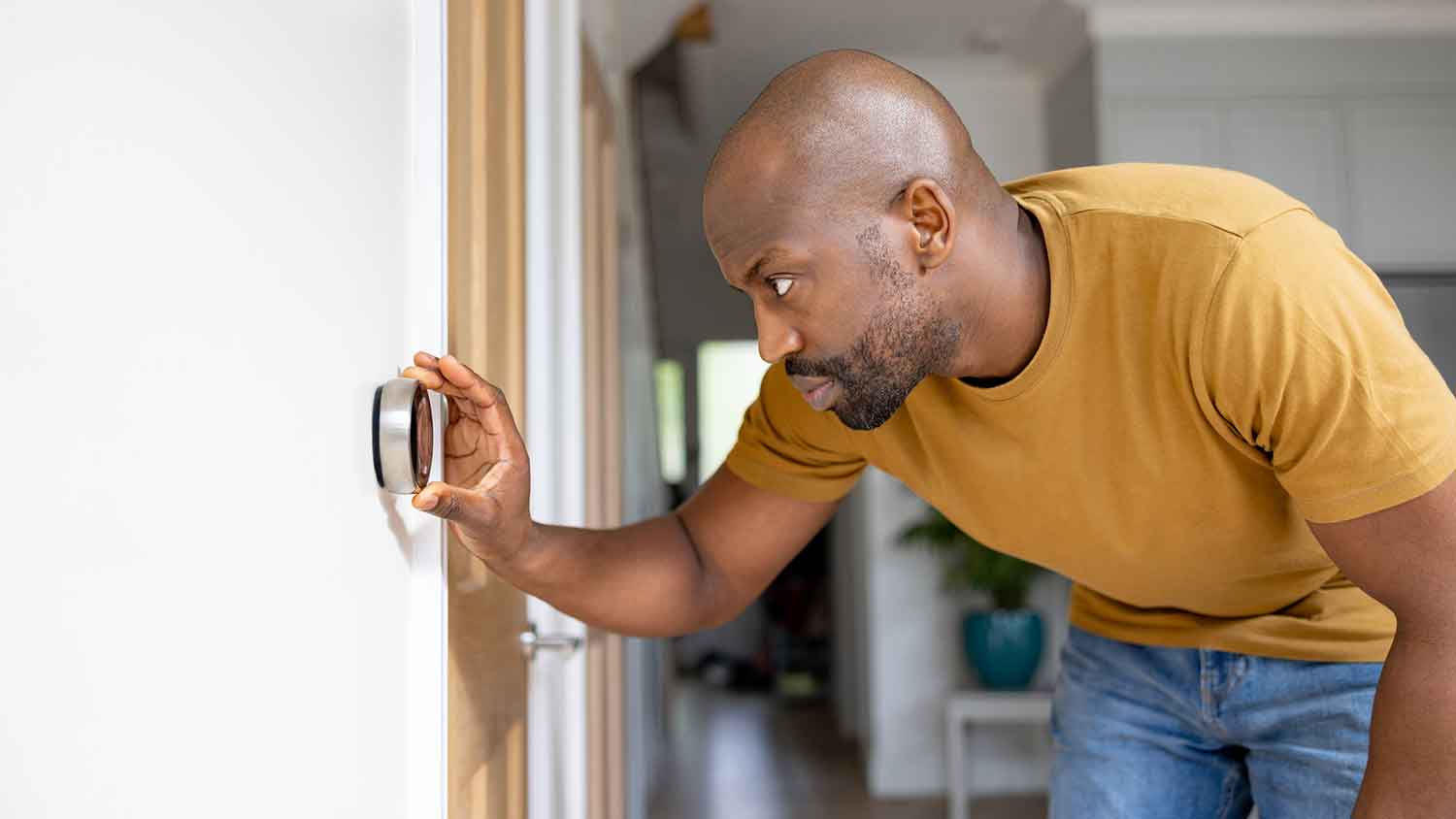 Man adjusting room temperature on the thermostat