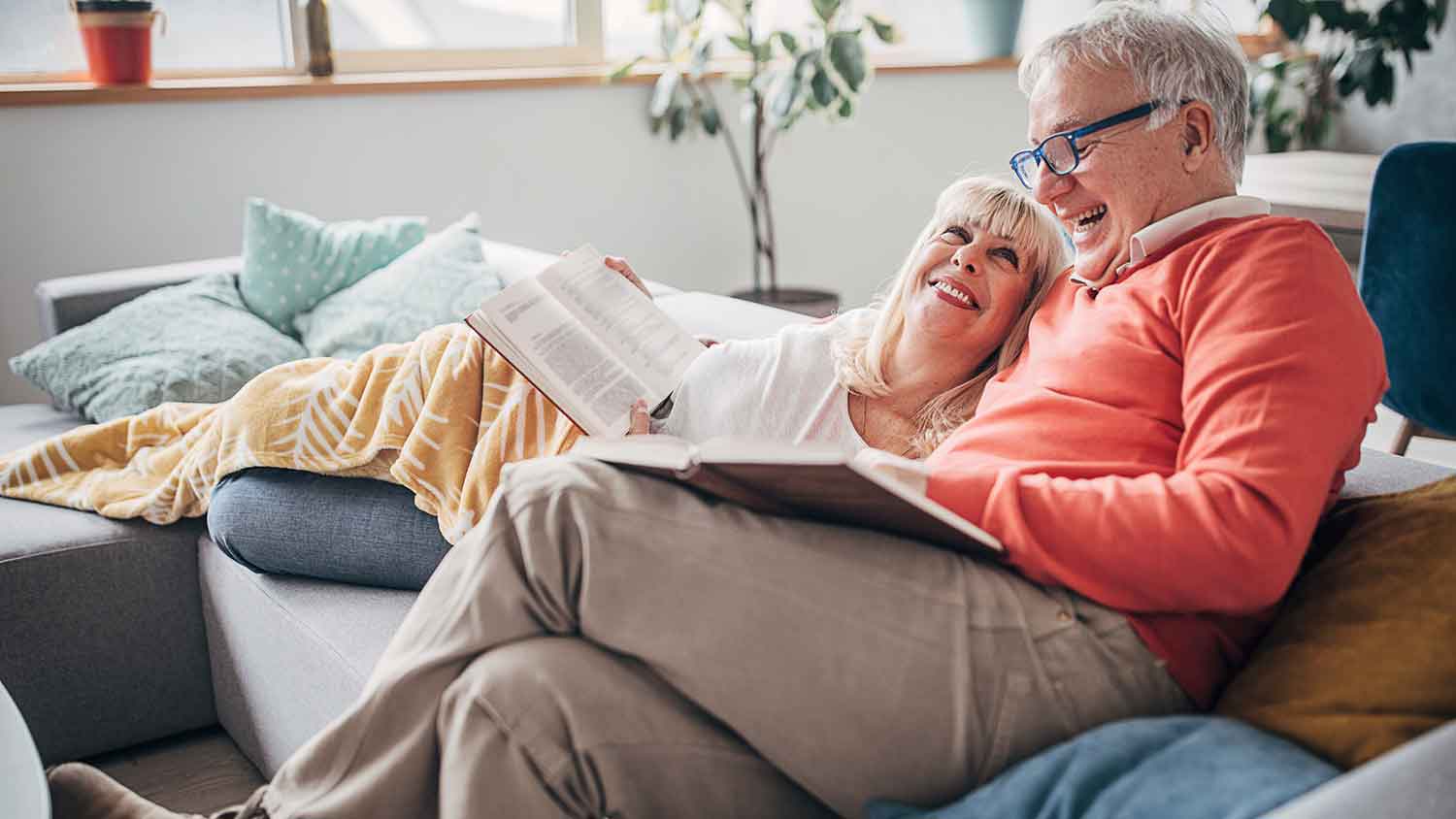 Senior couple sitting on a sofa spending time at home