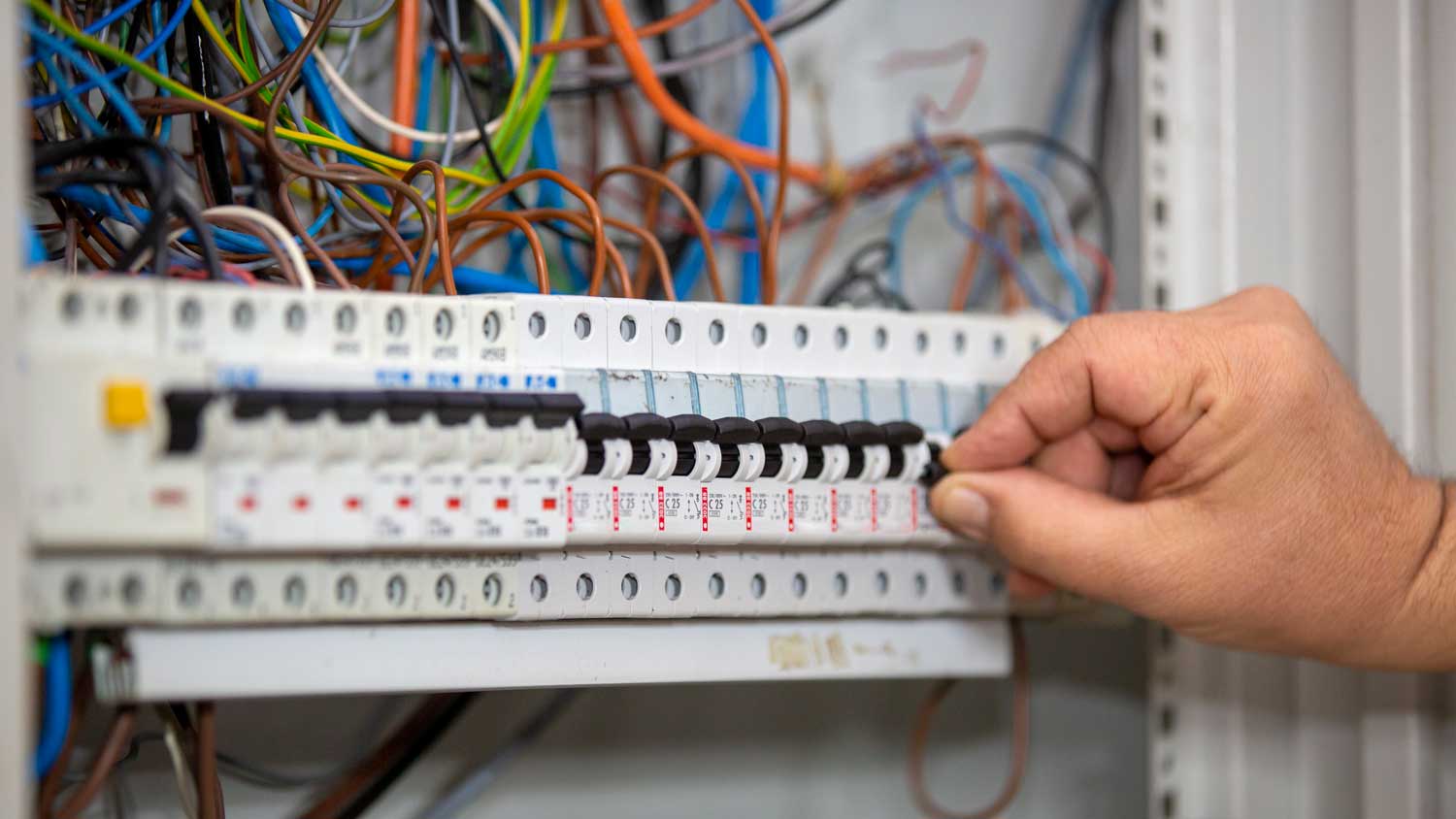 man switching electrical fuse switches
