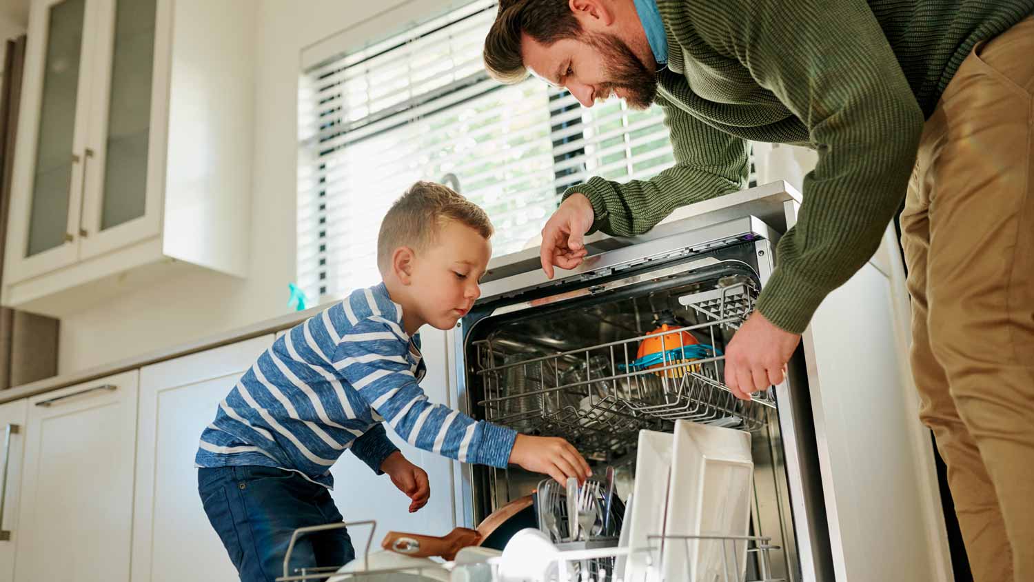 A father and his son loading the dishwasher
