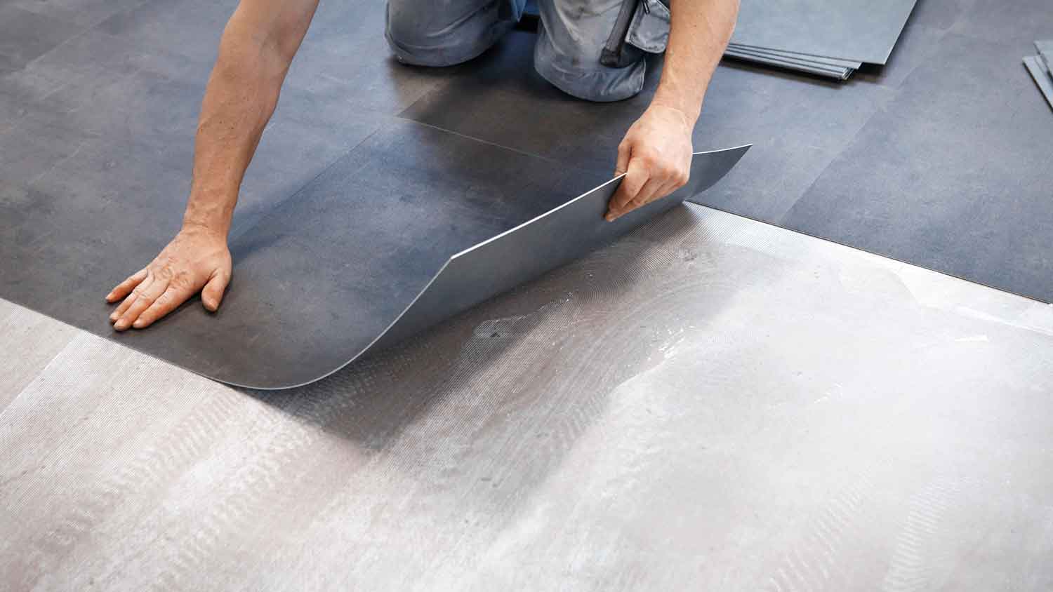 Worker installing gray vinyl tiles