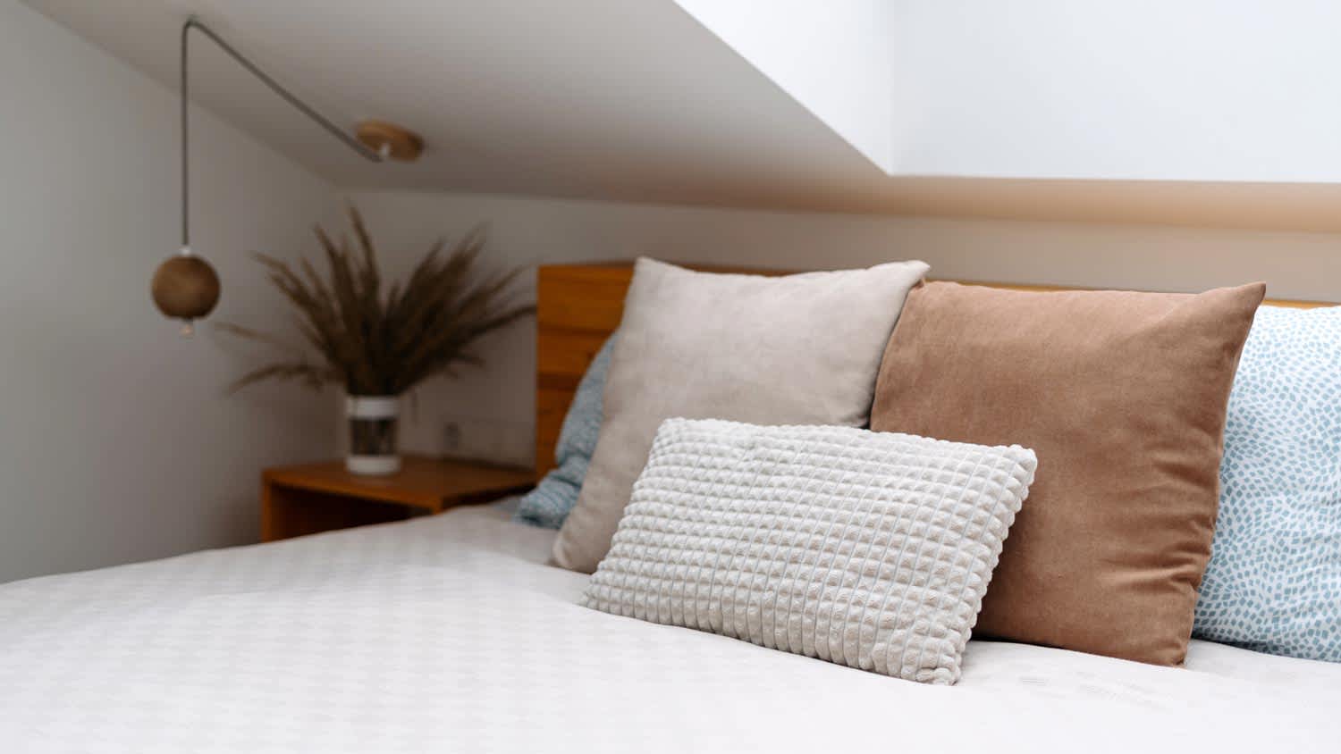 A memory foam mattress in a bedroom with a skylight