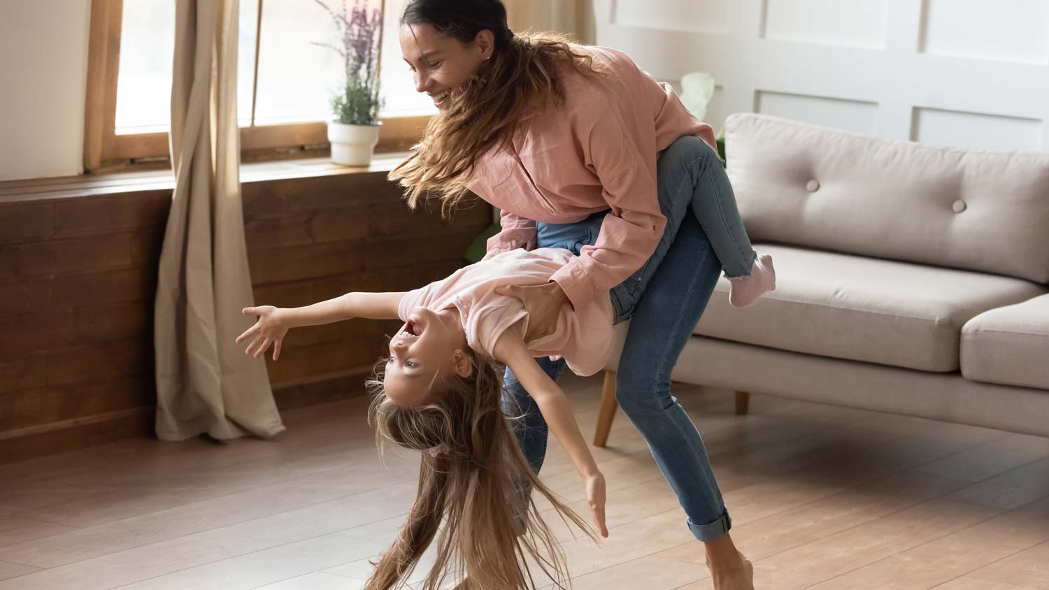 A mother and her daughter dancing on laminate floor