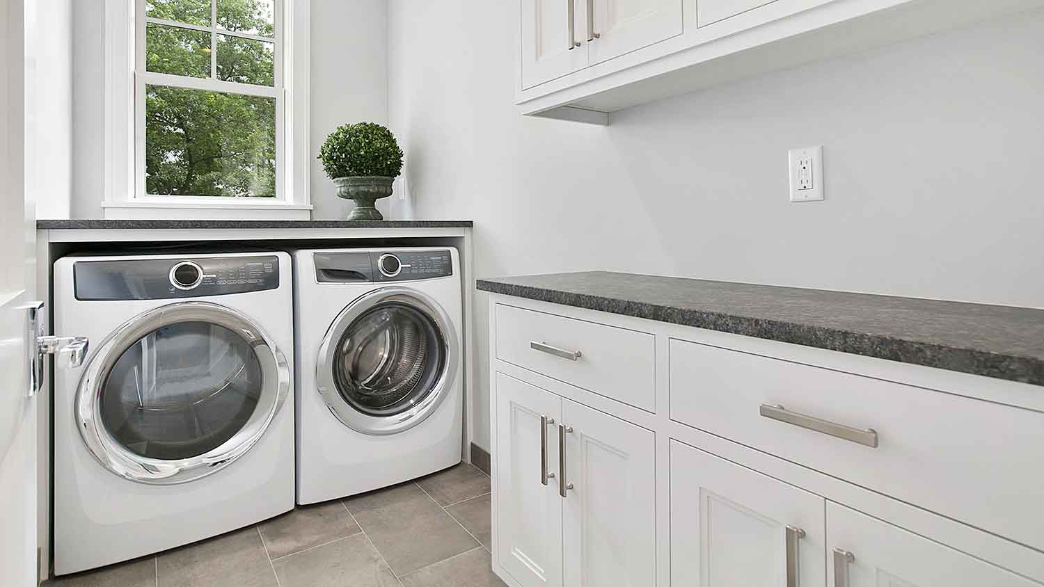Small laundry room with white cabinets