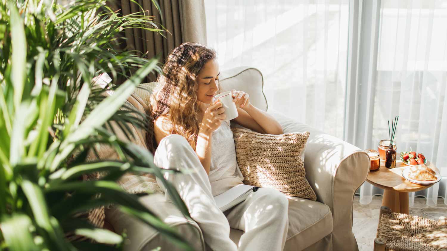 A woman enjoying her coffee in the living room