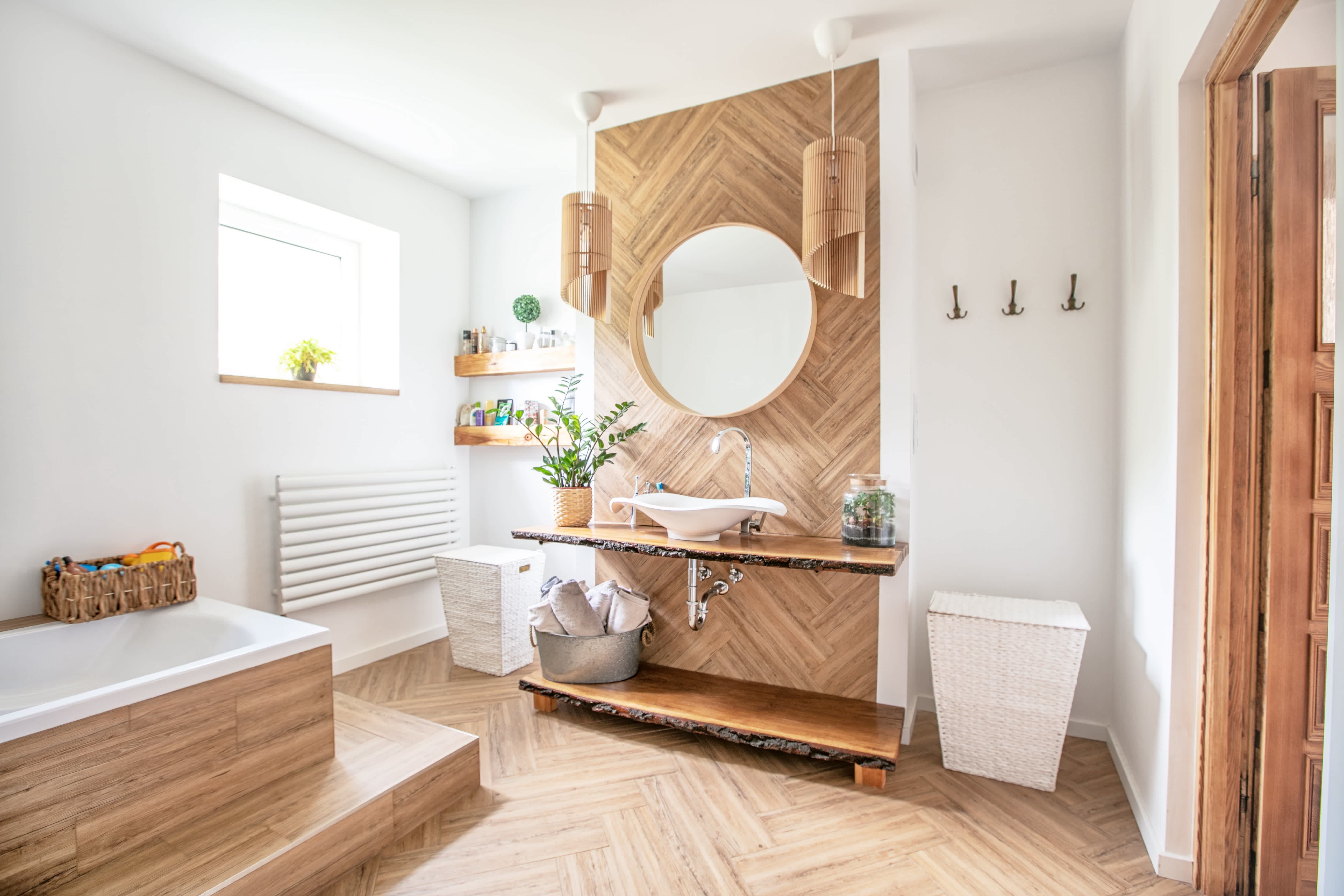 Boho bathroom with a wood chevron pattern sink backsplash and floor, wood tub surround, wood pendant lights, and vessel sink