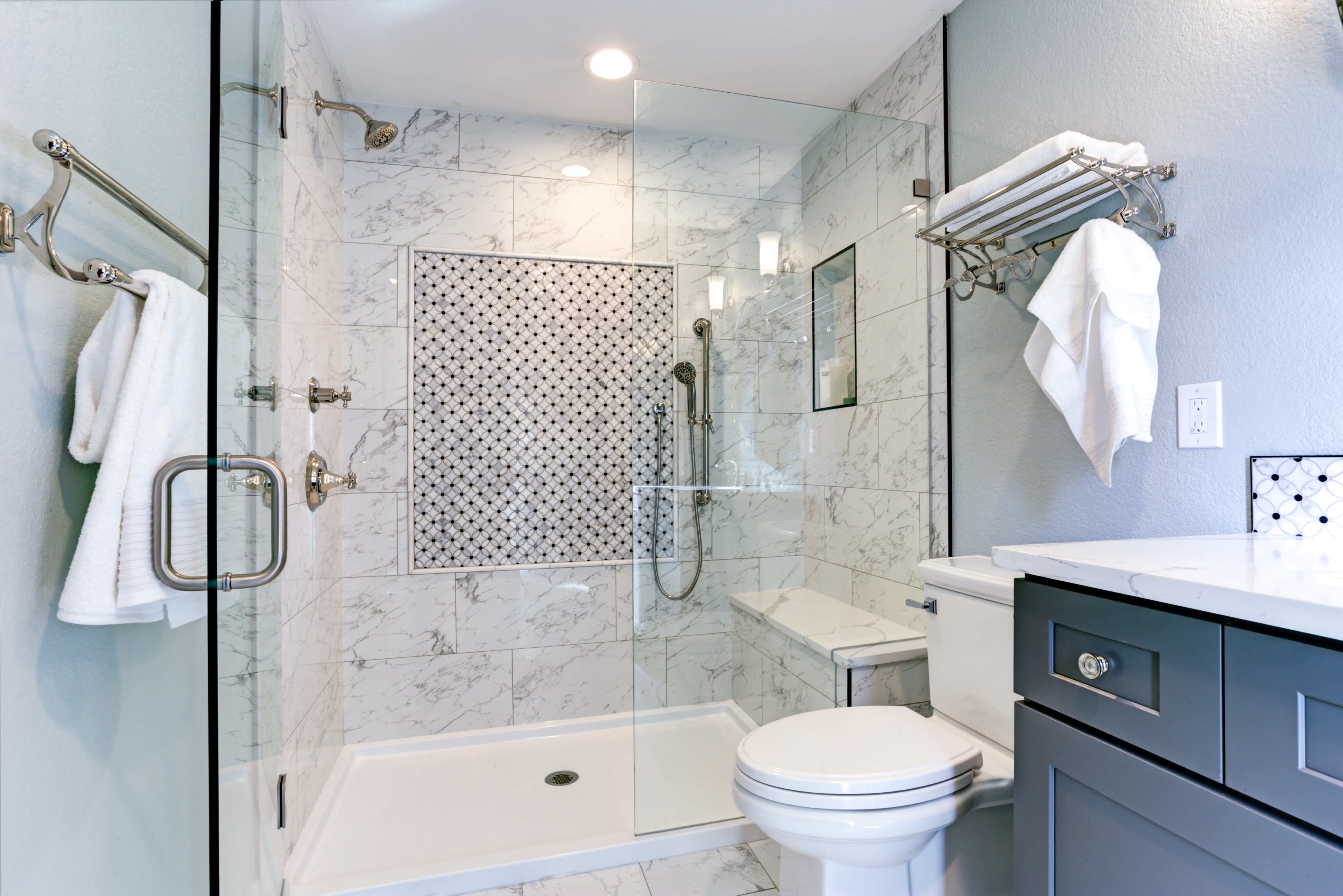 Small bathroom with marble shower surround and mosaic accent tiles