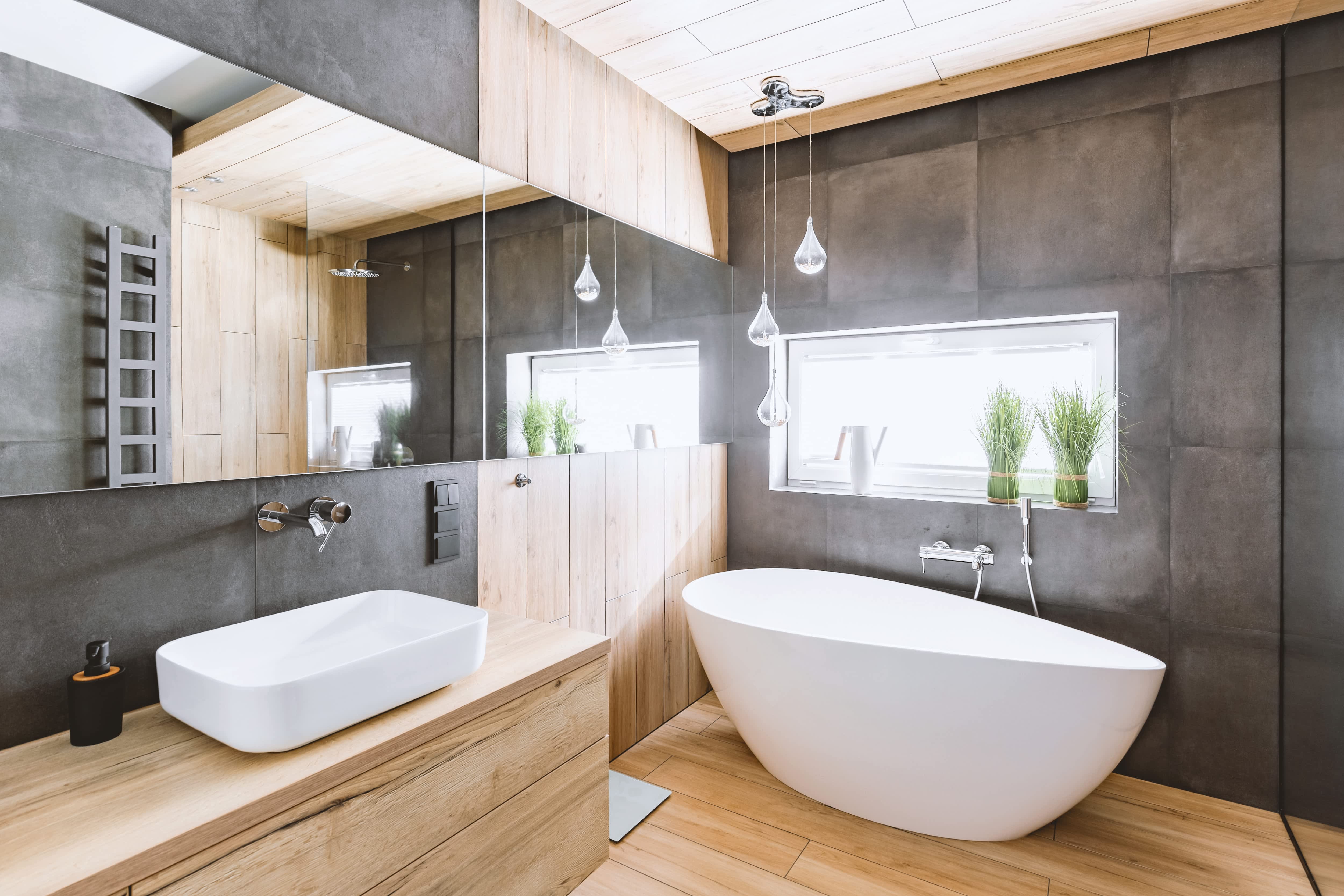 Industrial bathroom with wooden and concrete walls and white bath