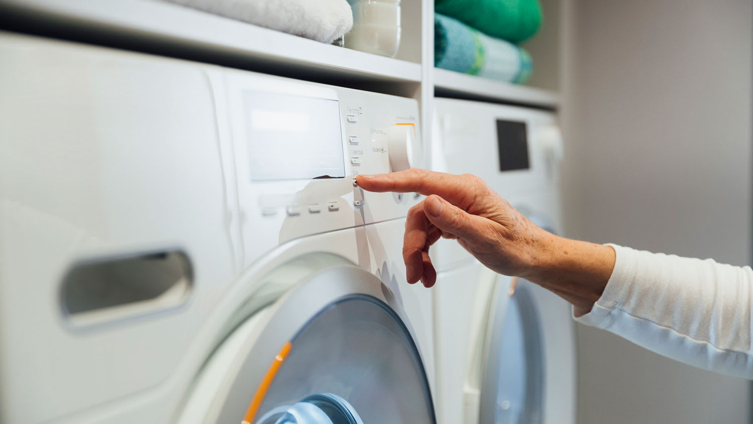A woman turning on the dryer