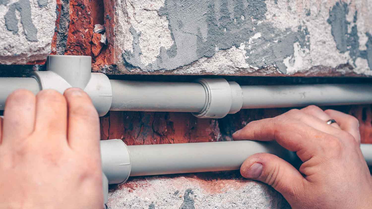 A person removing PVC pipes