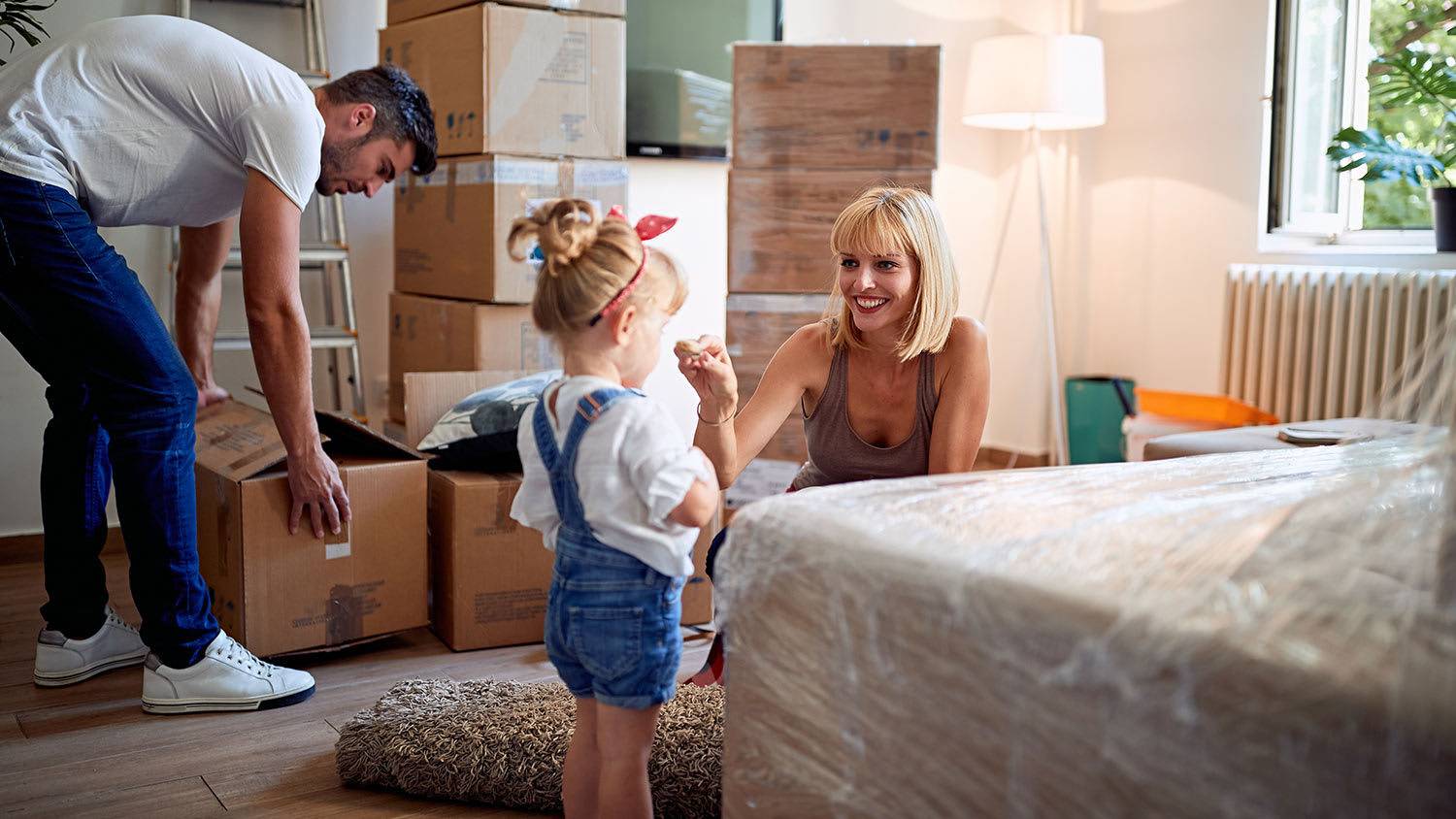 Family packing up a house while mom entertains toddler
