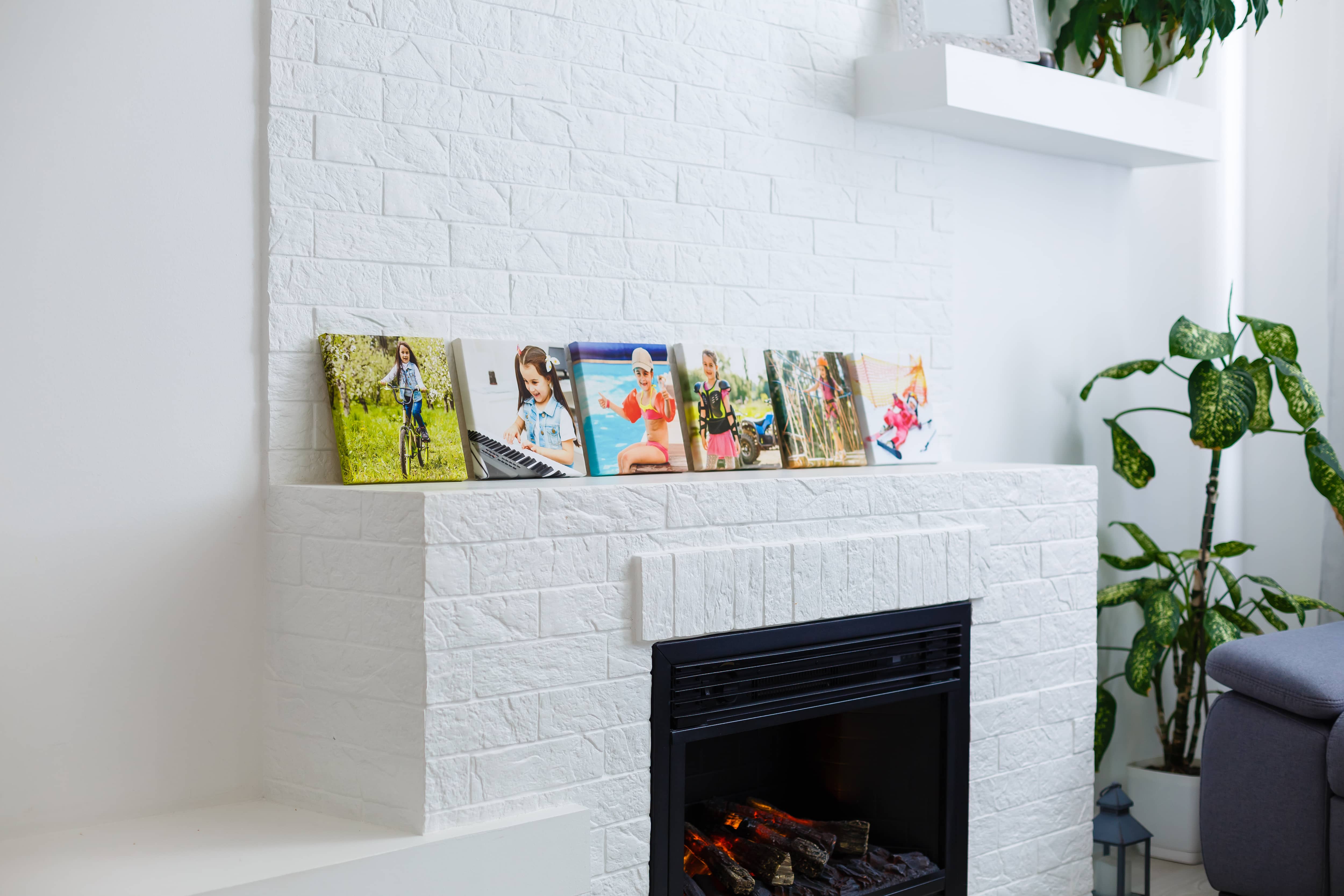 White brick fireplace with color canvas photos of children on the mantel