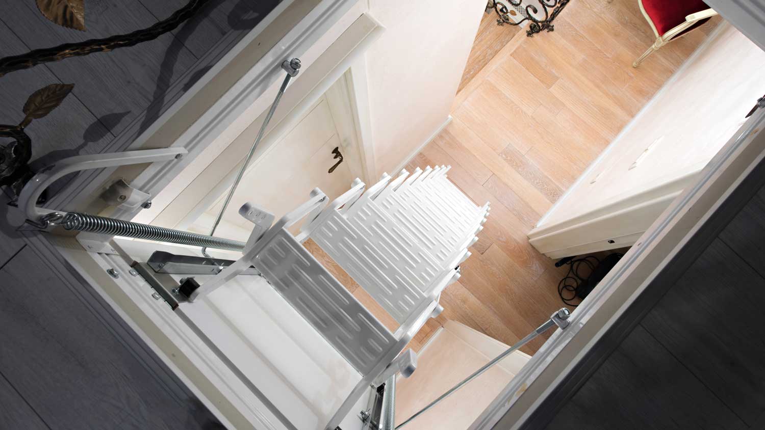 An open attic door with white stairs