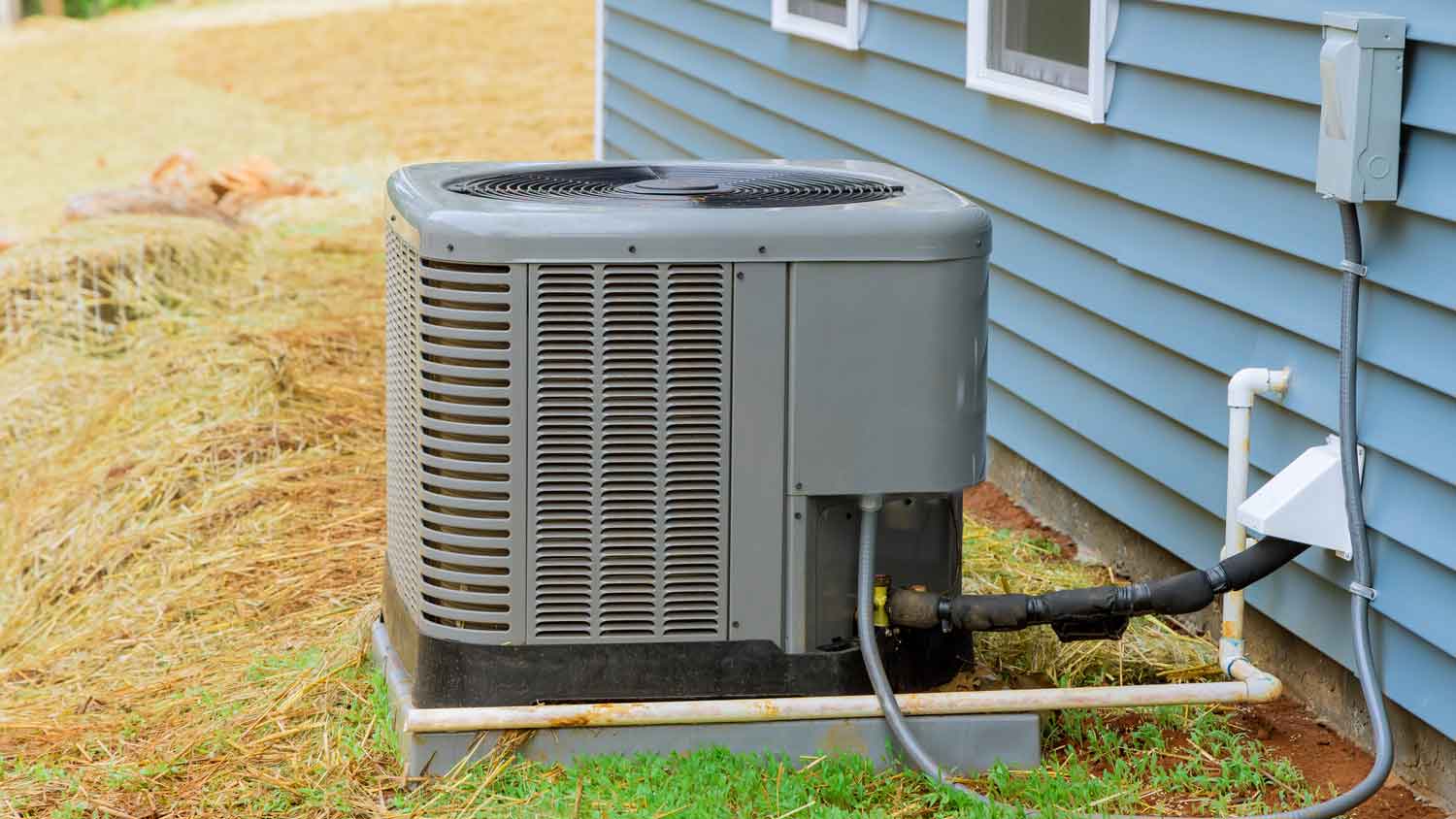 A HVAC system in the backyard of a house