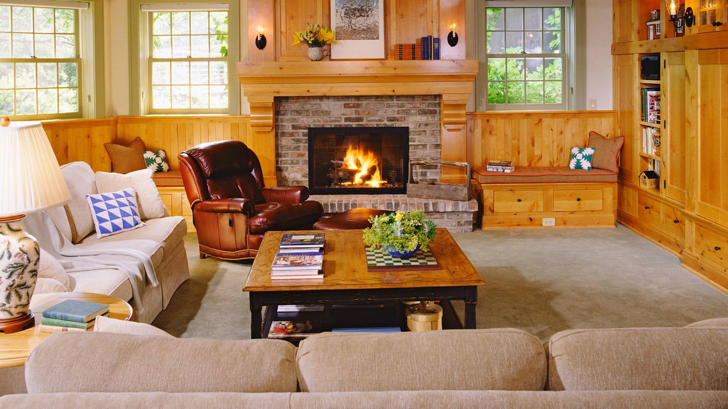 A living room with a fireplace located in the basement of a house