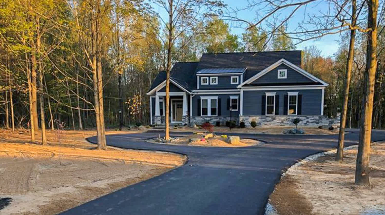 Dark gray house with asphalt driveway