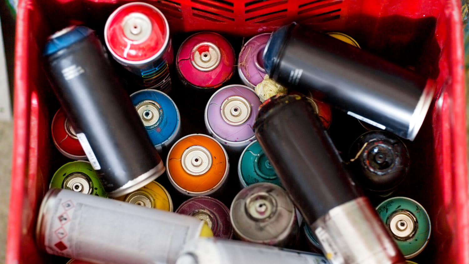 Spray paint cans in plastic crate
