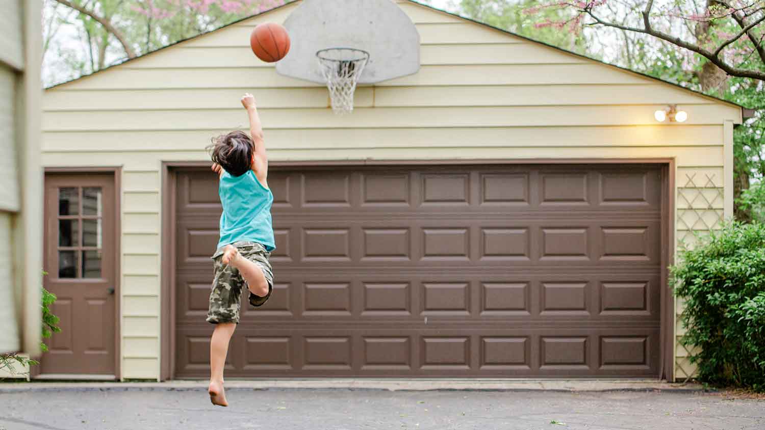 Boy playing basketball on the driveway
