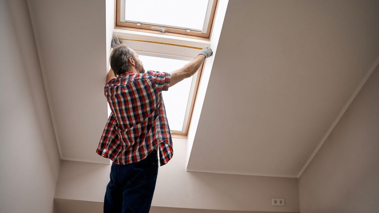 A man measuring the skylight opening