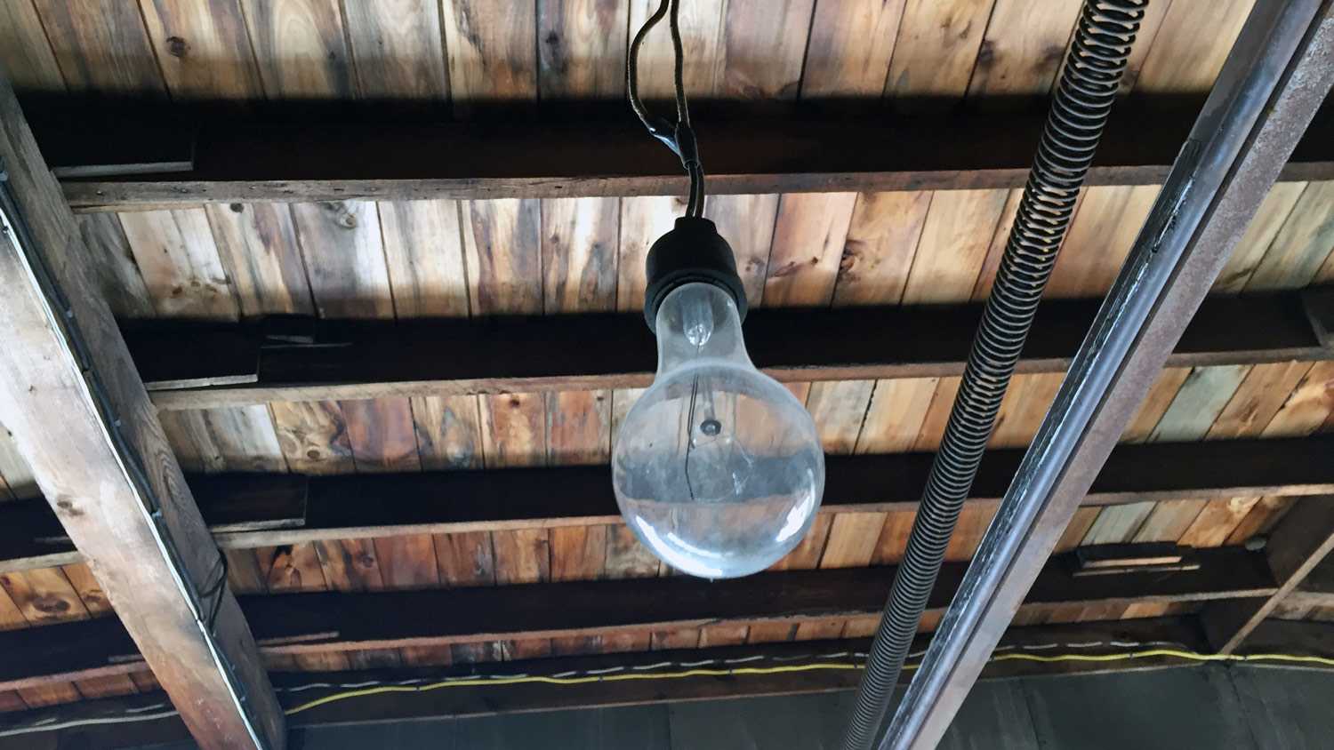 Light bulb hanging from basement ceiling