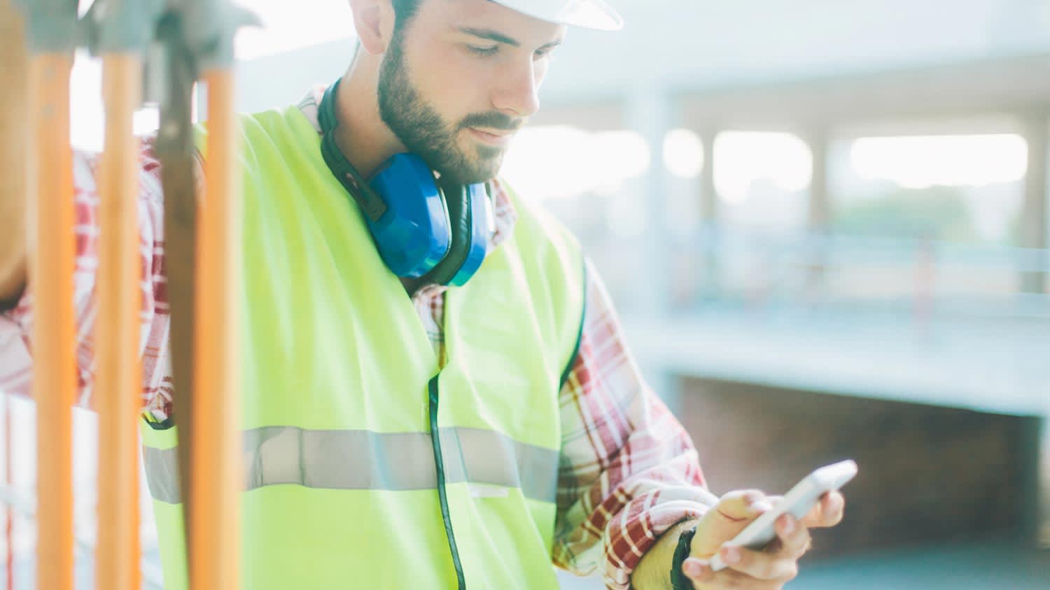 A constructor checking the weather on his phone