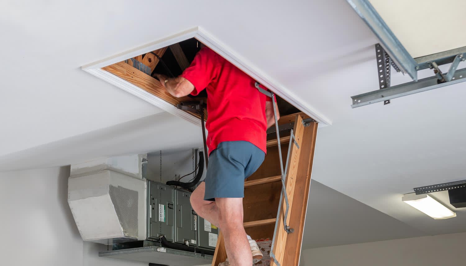 A man insulating an attic door