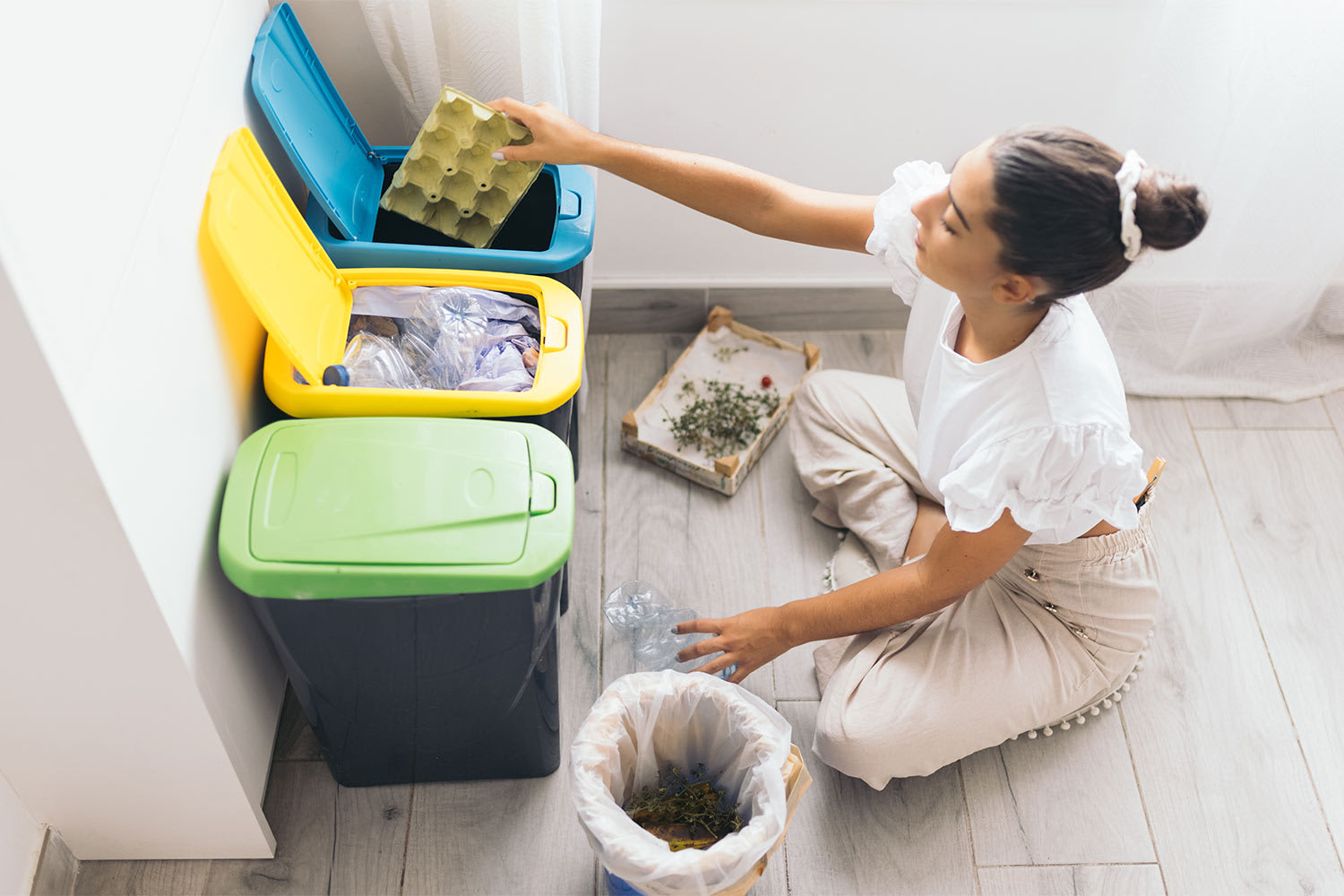 woman recycling plastic bottle in garbage bin