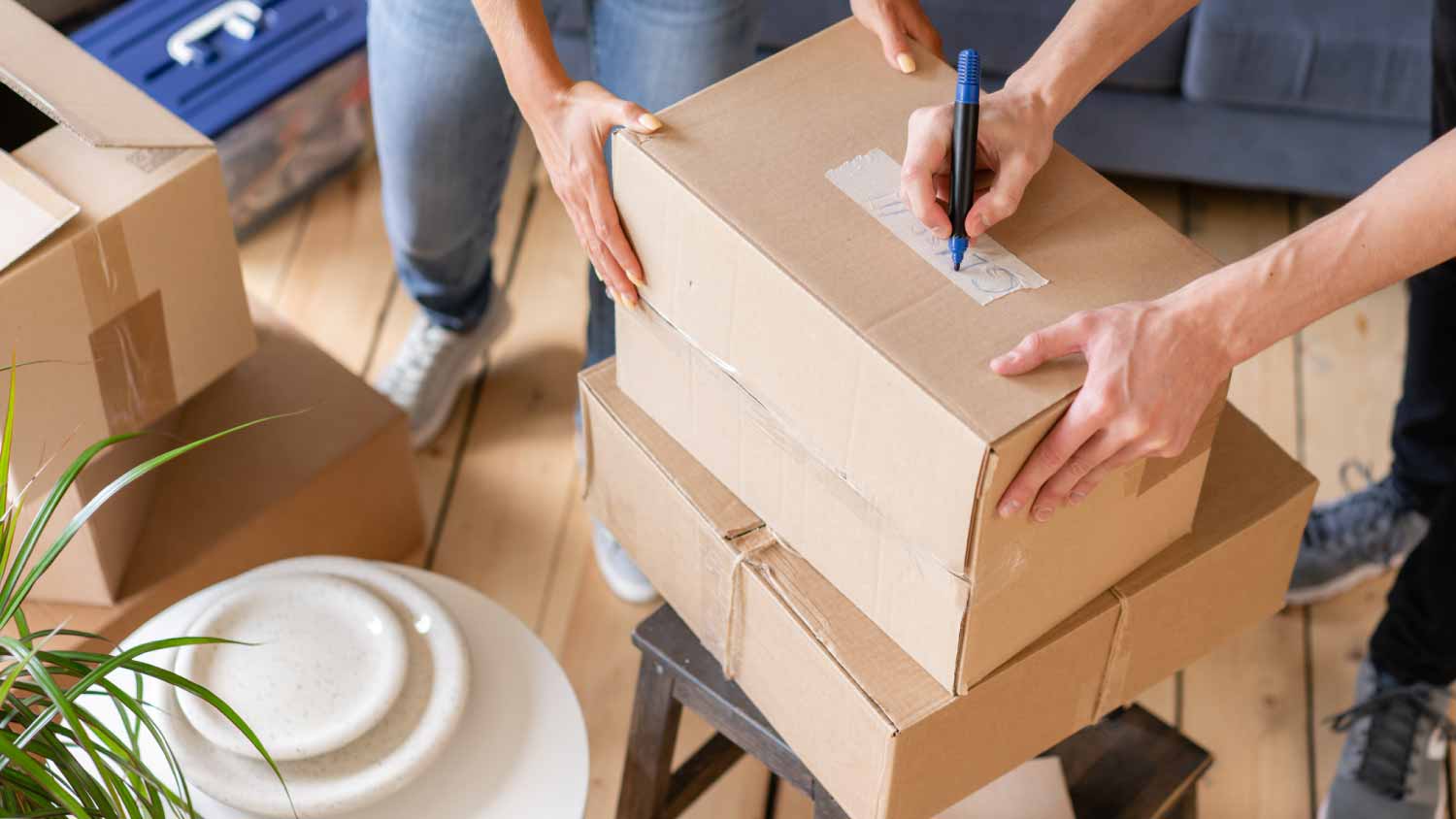 Close up of hand packing cardboard box
