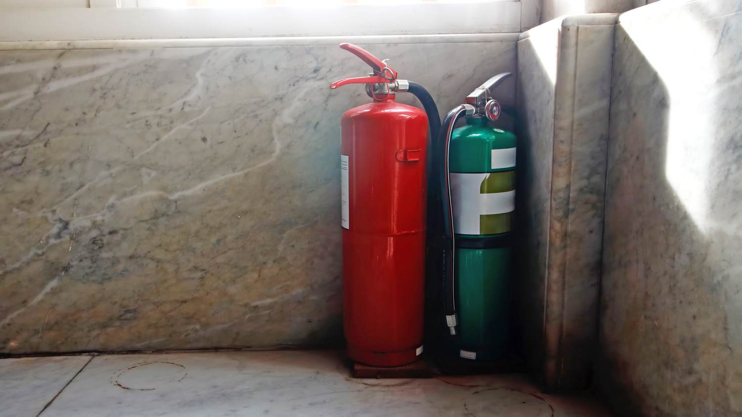 Green and red fire extinguishers placed in the building