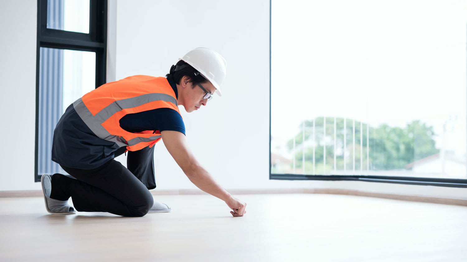 A professional inspecting wooden floor
