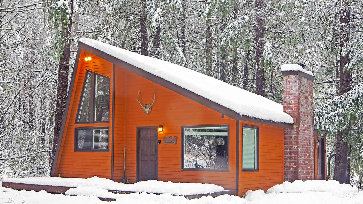 Orange siding cabin covered with snow