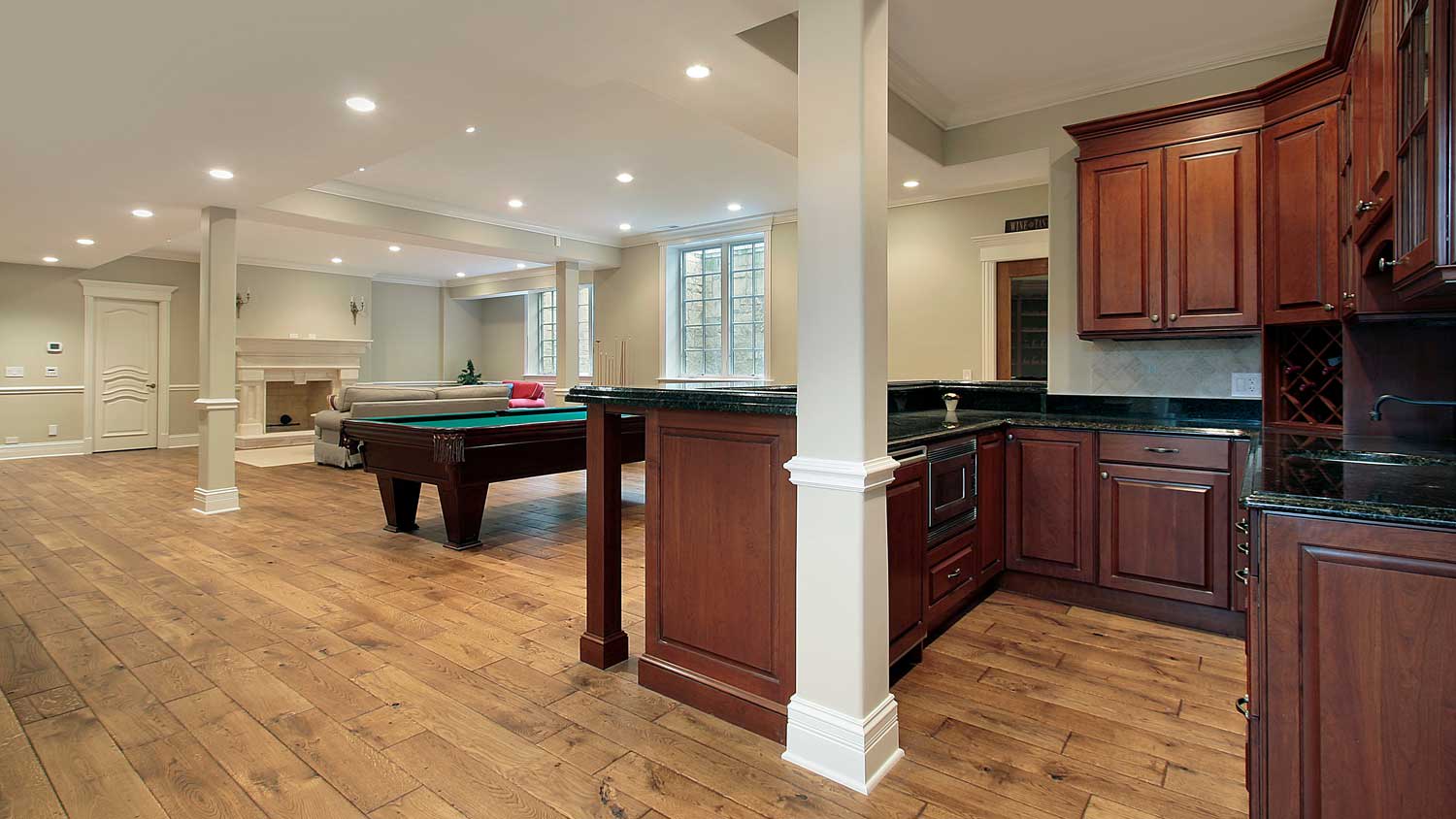 A house’s basement with a wooden bar and a fireplace