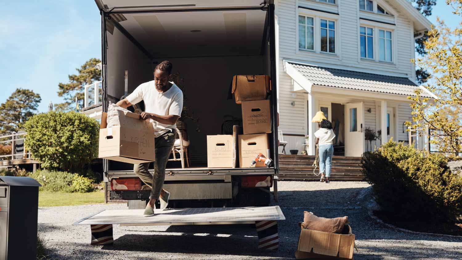 Man unloading cardboard box from van