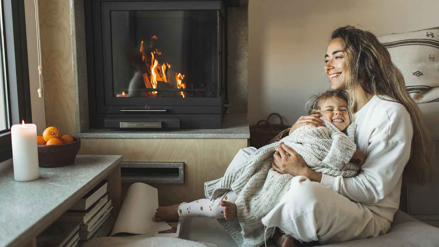 Mother and daughter having a good time sitting by the fireplace