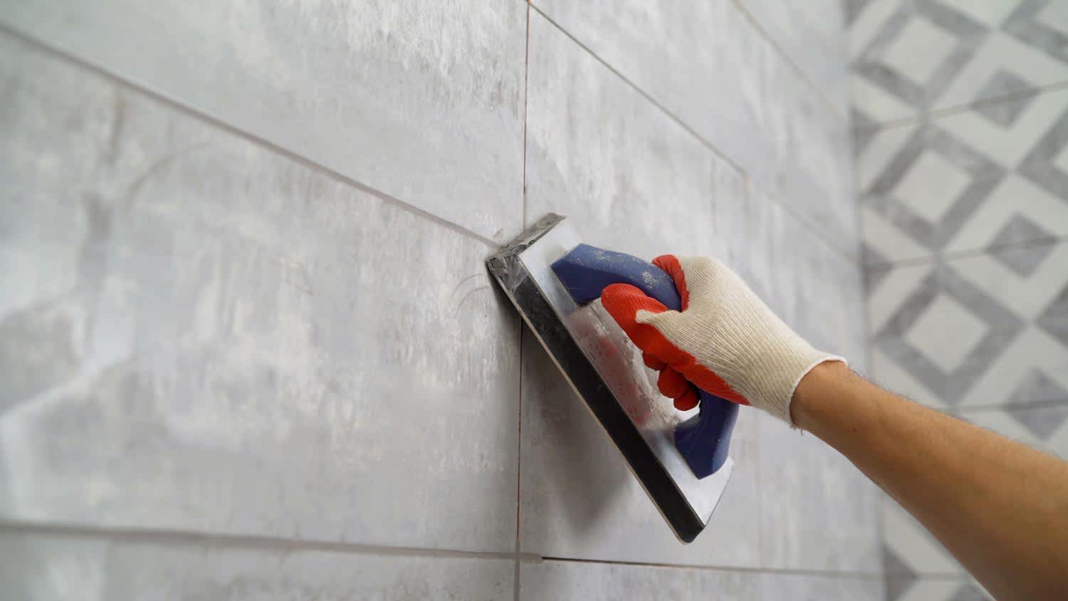 A person grouting wall tiles