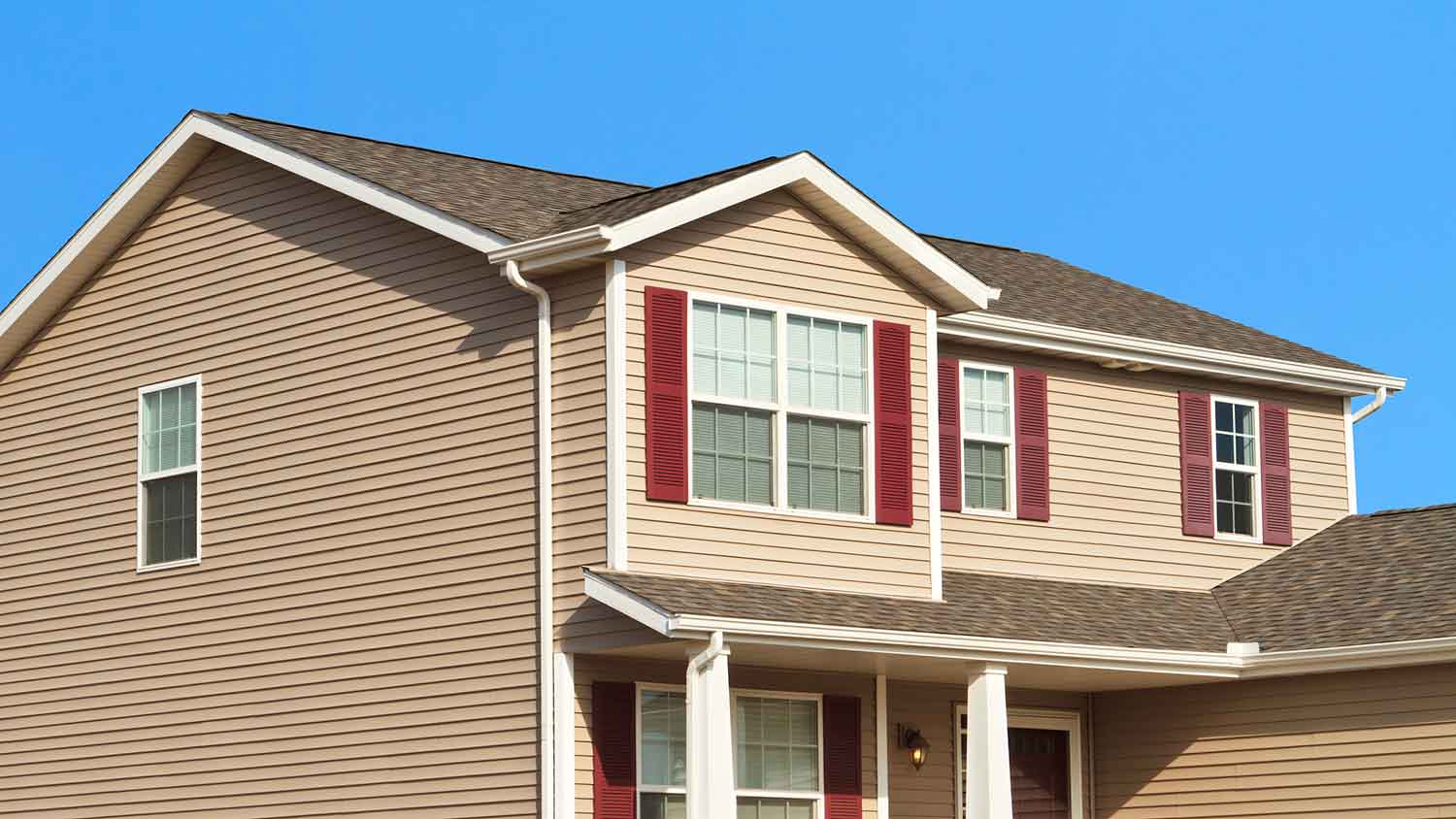 Large beige siding house with white gutters