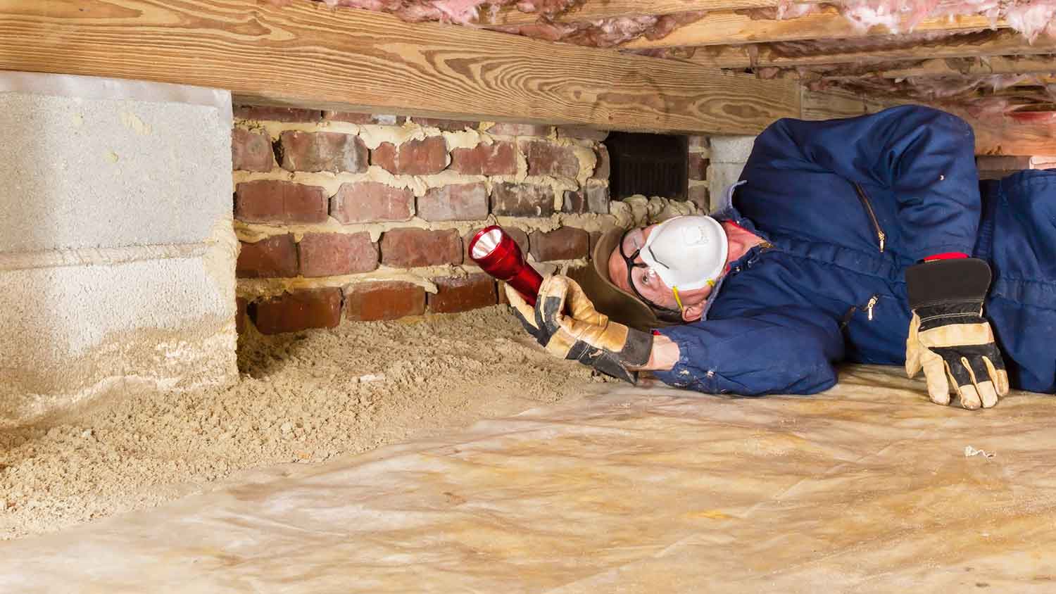 Inspector checking crawl space condition