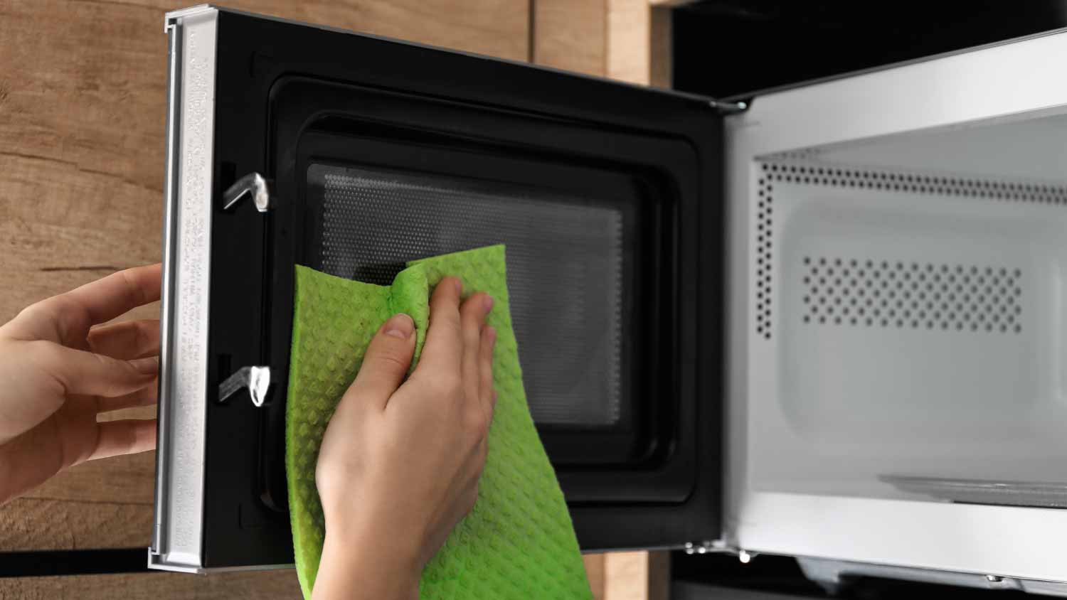 Woman cleaning microwave