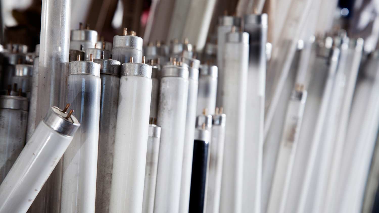 A stack of used up fluorescent light bulb tubes
