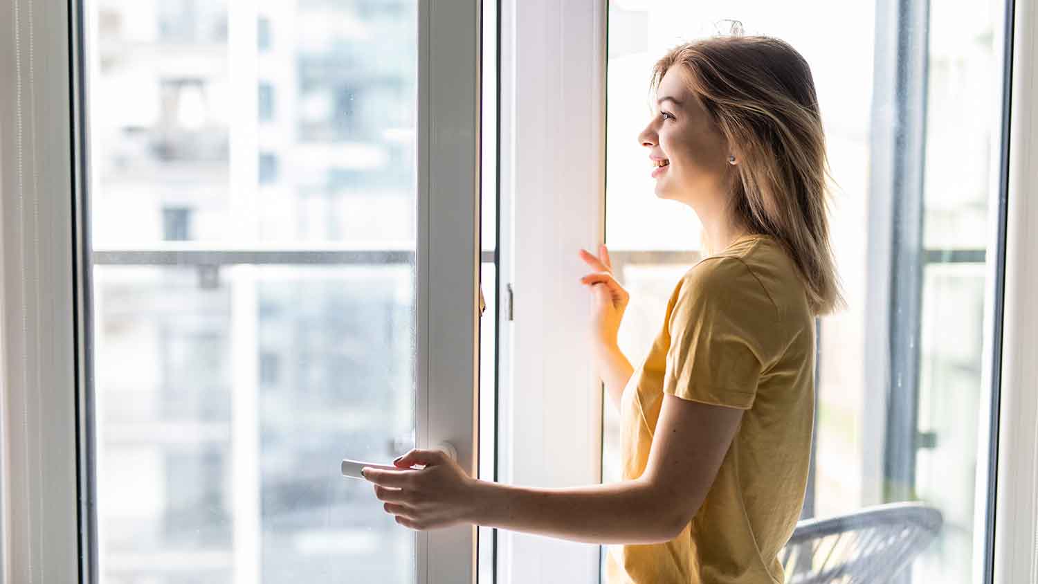 Woman opening single casement window at home