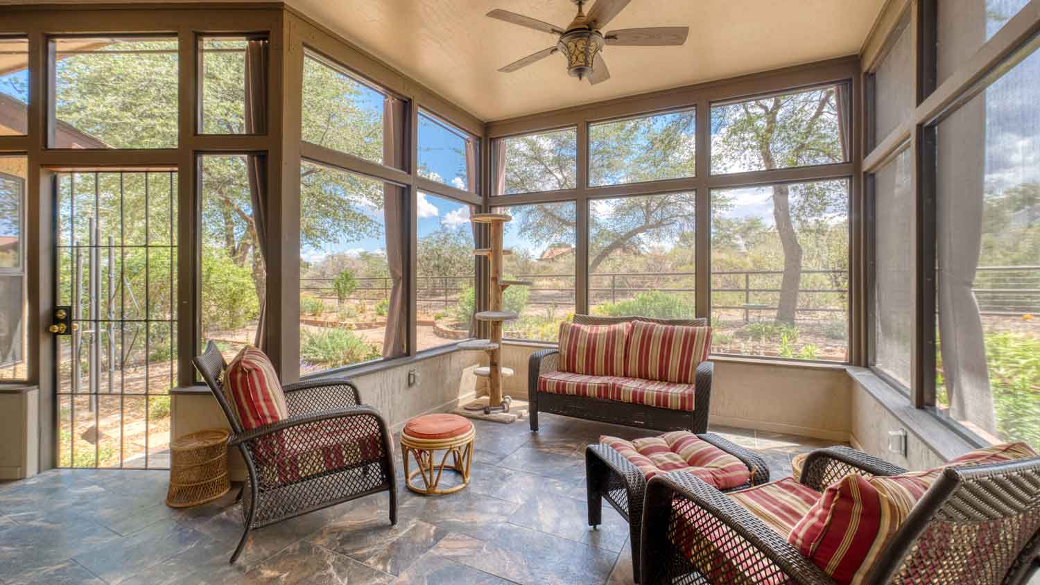 A screened porch with furniture